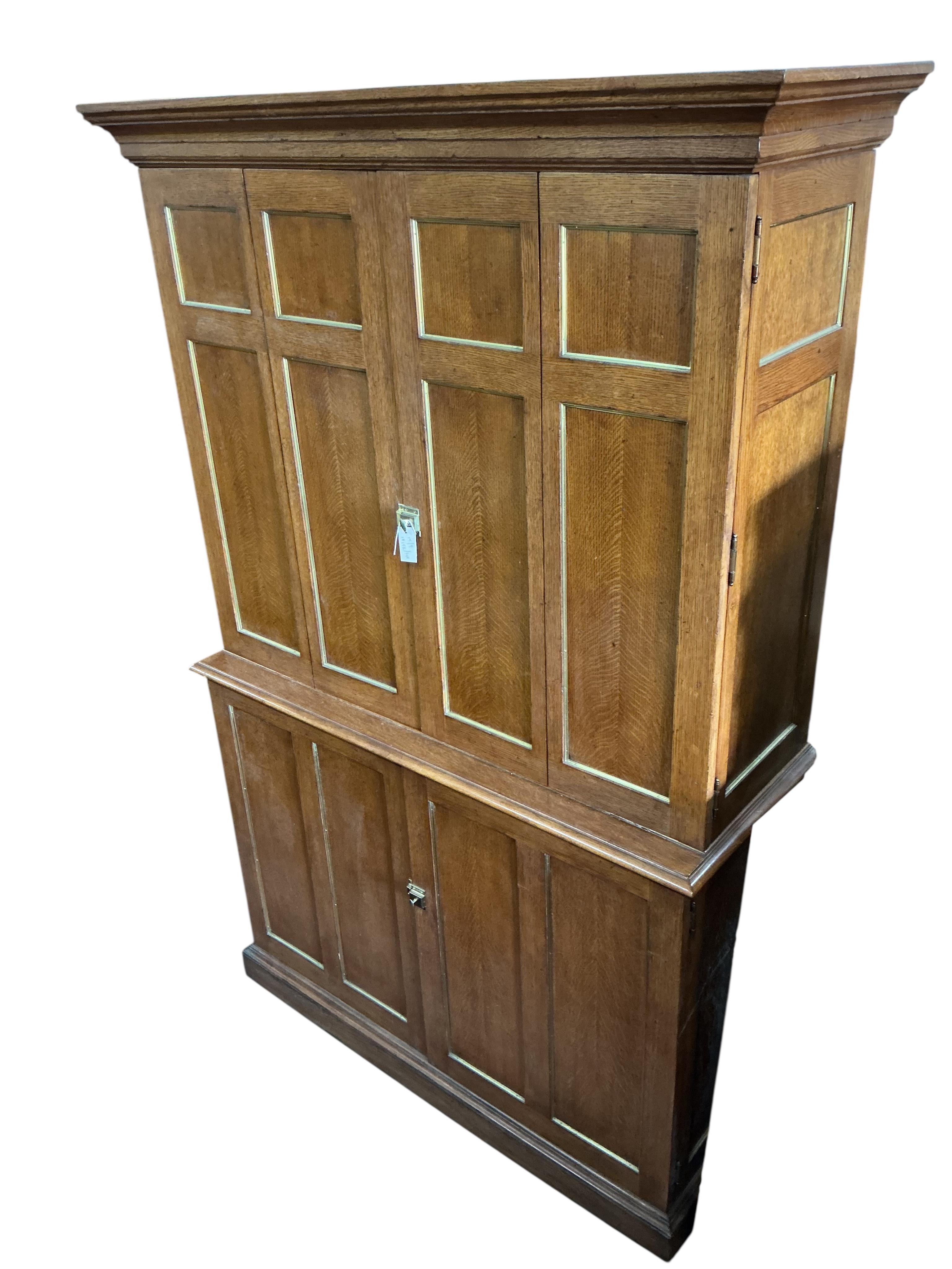 A brass mounted oak media cabinet, retailed by Ralph Lauren, upper section with bi-fold doors, width 140cm, depth 53cm, height 225cm